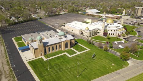 Aerial-Orbit-shot-of-Islamic-Center-of-America-side-by-side-with-Christian-church,-Dearborn-Michigan