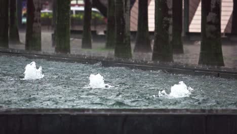 A-stationary-slow-motion-footage-of-three-water-fountains-in-a-public-park-in-Hong-Kong-with-a-rainy-weather