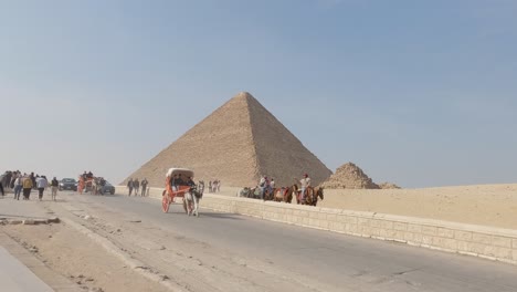 Establishing-Shot-Giza-Pyramids-Landscape,-traffic-road-with-touristic-Horse-Carriage,-Egypt