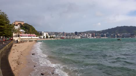 A-choppy-harbour-and-empty-beach-along-waterfront-on-a-windy-winters-day-in-Oriental-Parade-in-capital-Wellington,-New-Zealand-Aotearoa