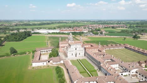 Aerial-view-of-the-Certosa-di-Pavia-at-sunny-day,-built-in-the-late-fourteenth-century,-courts-and-the-cloister-of-the-monastery-and-shrine-in-the-province-of-Pavia,-Lombardia,-Italy