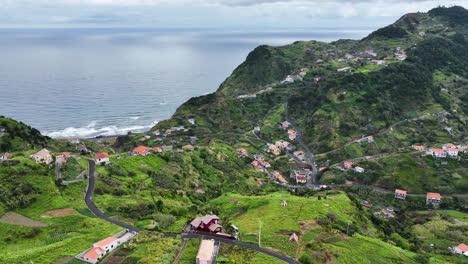 Village-on-Madeira-coastline-in-lush-hilly-landscape