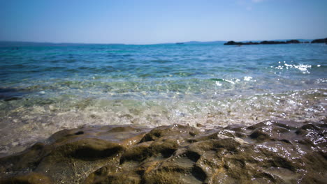Aguas-Cristalinas-Y-Tranquilas-Del-Mediterráneo-Rompen-Suavemente-En-Una-Playa-Rocosa