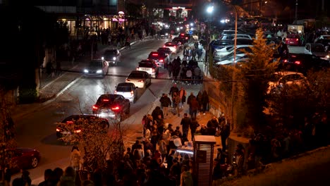 Busy-Tirana-Street-at-Night:-A-Crowd-of-Pedestrians-Walking-Amidst-Heavy-Traffic
