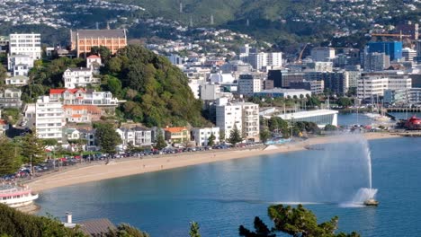 Stunning-Oriental-Bay-with-water-fountain,-beach,-ocean-and-waterfront-residential-houses-in-the-capital-Wellington,-New-Zealand-Aotearoa