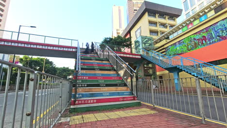 Timelapse-of-people-walking-down-the-colorful-Olympic-Footbridge-in-Causeway,-Hong-Kong