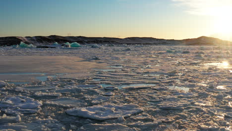 Laguna-Glaciar-Jökulsárlón-Islandia-En-Invierno,-Volando-Sobre-Una-Vasta-Superficie-De-Agua-Glacial-Derretida-Y-Bloques-De-Hielo-Congelados-Flotantes-Icebergs,-Destino-Turístico-En-Clima-Frío