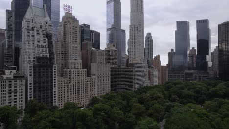Aerial-view-rising-up-from-the-Central-Park-in-front-of-high-rise-in-MIdtown,-NYC,-USA---Ascending,-drone-shot