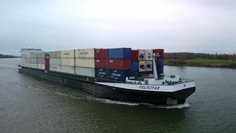 Huge-containership-navigating-through-the-canal-of-"-De-Oude-Maas"-in-Zwijndrecht,-The-Netherlands