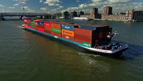Cargo-ship-with-containers-navigating-through-the-city-of-Zwijndrecht-in-The-Netherlands