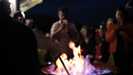 woman-reciting-incantation-of-the-Queimada-drink-in-front-of-public-at-night-between-flames