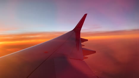 Wizz-Air-plane-wing-and-logo-flying-through-sky-to-Morocco-at-sunset