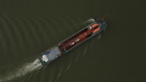 Aerial-topdown-view-of-vessel-ship-with-crane-floating-on-water-in-static-shot