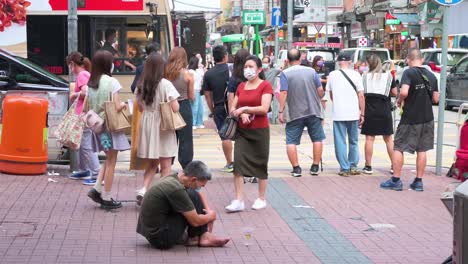 Un-Hombre-Desempleado-Pide-Dinero-Mientras-Los-Peatones-Pasan-Junto-A-él-En-Las-Calles-De-Hong-Kong