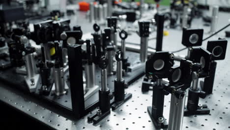 Horizontal-pan-over-an-optical-table-with-different-laser-and-mirror-elements-for-precise-scientific-measurements