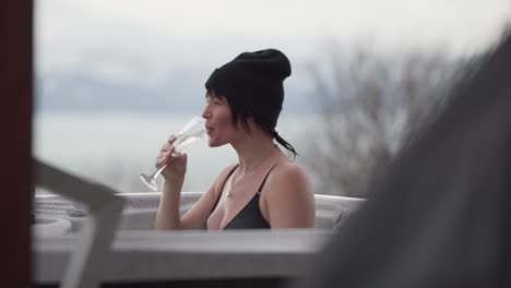 Two-female-friends,-drinking-champagne,-in-a-hot-tub,-in-Homer-Alaska