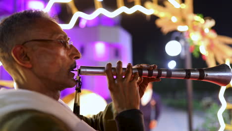 An-old-oriental-man-playing-the-oboe-at-an-oriental-Egyptian-wedding-ceremony-from-the-side--close-shot