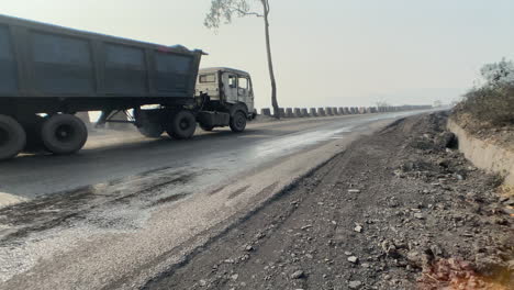 Ground-level-shot-of-coal-trucks-passing-on-a-road