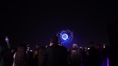 Spectacle-in-the-Sky:-Captivating-Nighttime-Drone-Show-Draws-Crowd-for-People-Watching-and-Smartphone-Filming