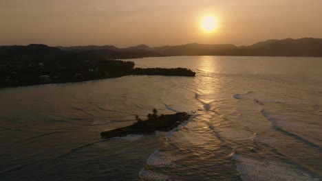 Cinematic-drone-flight-over-Caribbean-Sea-with-small-island-during-sunset-time
