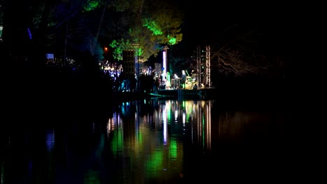 Live-concert-on-a-spring-night-near-the-lake-in-the-city-park-among-the-lights-reflecting-in-the-water