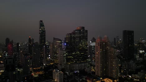 Atemberaubende-Skyline-Der-Stadt-Bangkok-Spät-In-Der-Nacht.-Drohnenaufnahmen-Aus-Der-Luft-Vom-Zentralen-Geschäftsviertel-Sathorn