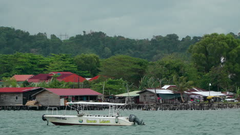 Water-VIllage-and-Tourist-Boat-in-Bay-Area-of-Kampung-Tanjung-Aru-Lama-District,-Low-Income-Immigrant-Houses-In-Sabah,-Kota-Kinabalu
