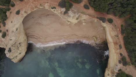 Aerial-top-down-view-above-Algarve-Benagil-caves,-Portugal-transparent-ocean-coastline
