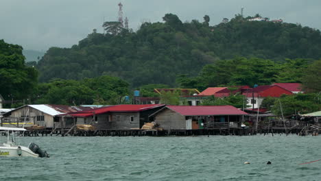 Old-Wooden-Houses-on-Water-in-Bay-Area-of-Kampung-Tanjung-Aru-Lama-District,-Low-Income-People's-Homes-In-Sabah,-Kota-Kinabalu