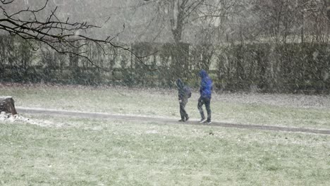 Menschen,-Die-Kinder-Bei-Schneiendem,-Kaltem-Wetter-Und-Windigen-Winterstürmen-In-Großbritannien-Zur-Schule-Bringen