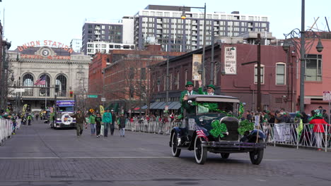 A-classic-car-loaded-with-green-decorations-driving-slowly-through-Denver's-downtown-Saint-Patrick's-Day-parade