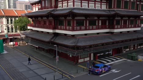 Top-view-of-passengers-boarding-a-taxi-outside-the-Buddha-Tooth-Relic-Temple-in-Chinatown,-Singapore