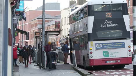 Bus-Eireann-bus-stopped-at-bus-station-with-people-on-Washington-street,-Cork-City,-Ireland