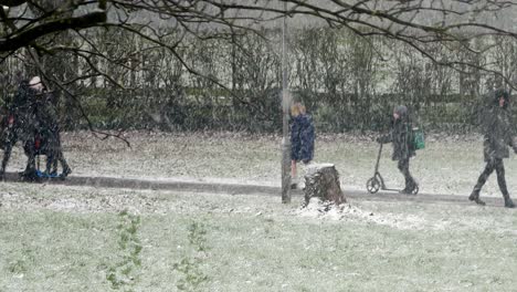 People-walking-kids-to-school-in-blizzard-snow-cold-weather-in-windy-UK-winter-storm