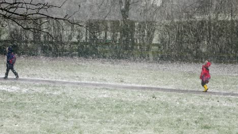 Gente-Caminando-Niños-A-La-Escuela-En-Ventisca-Nieve-Clima-Frío-En-Ventoso-Reino-Unido-Tormenta-De-Invierno
