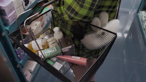 Woman-carrying-shopping-basket-with-lots-of-cosmetics-products