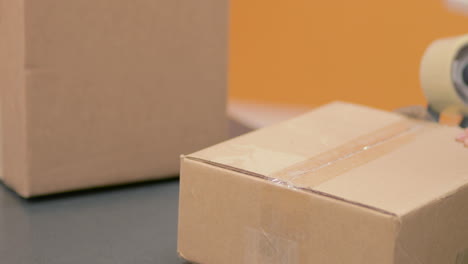 Verkleben-Und-Versiegeln-Eines-Paketkartons-Für-Den-Versand