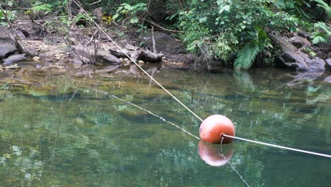 Orange-buoy-floating-on-clear-water.-4K