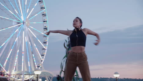 Young,-female,-contemporary-dancer-near-an-urban-Ferris-wheel