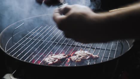 Taking-meat-out-of-the-grill-isolated-on-black-background