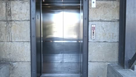 Doors-opening-and-closing-on-carpark-elevator-with-camera-zooming-in