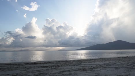 Zeitraffer-Am-Strand-Bei-Sonnenuntergang-Mit-Sonnenstrahlen-Durch-Die-Wolken