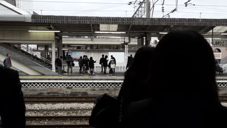 Siluetas-De-Personas-Esperando-En-La-Estación-De-Tren-En-Japón