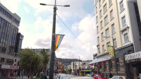 Slow-motion-tilt-up-revealing-flag-flying-on-windy-day-in-downtown-Wellington