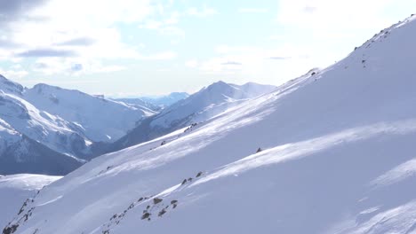 Imágenes-En-4k-De-La-Nieve-Que-Vuela-Por-El-Costado-De-La-Ladera-De-Una-Montaña