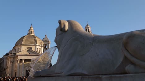 The-twin-churches-in-peopleâ€™s-square-in-Rome-with-lions-fountain-in-foreground-in-slow-motion