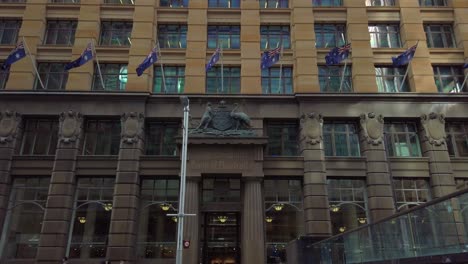 Edificio-Histórico-Del-Commonwealth-Bank-Of-Australia-Con-Banderas-Australianas-En-Martin-Place,-Sydney,-Australia