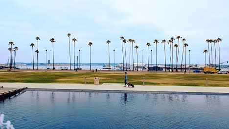 San-Diego-fountain-walk-in-slow-motion-with-ocean-and-palm-trees-in-the-background