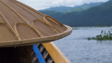 Traditional-Myanmar-bamboo-hat-on-person-boating-across-Inle-Lake