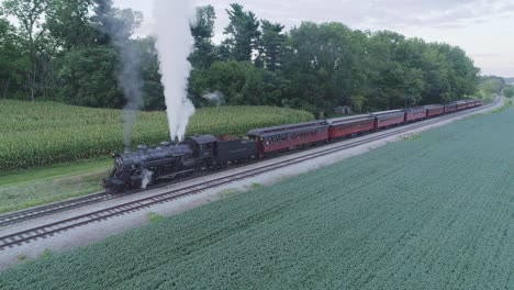 Luftaufnahme-Eines-Dampfzugs,-Der-An-Einem-Sommertag-An-Einem-Bahnhof-In-Der-Amish-Landschaft-Wartet